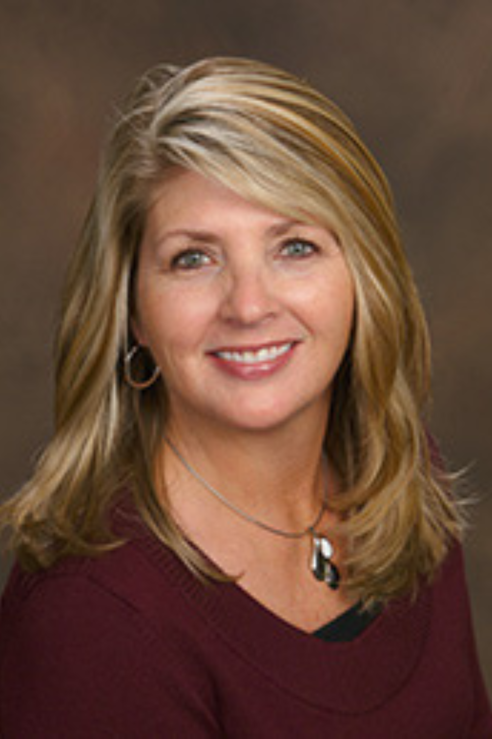 Portrait of Christine Engel, a dedicated Realtor with a dynamic background in housing and real estate, reflecting her expertise and community focus.